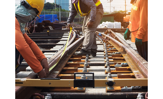 Workers performing maintenance on railroad tracks.